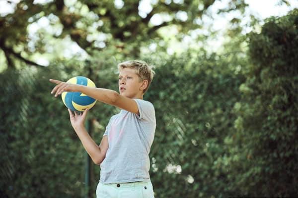 Junge mit Volleyball in der Hand im Englischcamp am Edersee