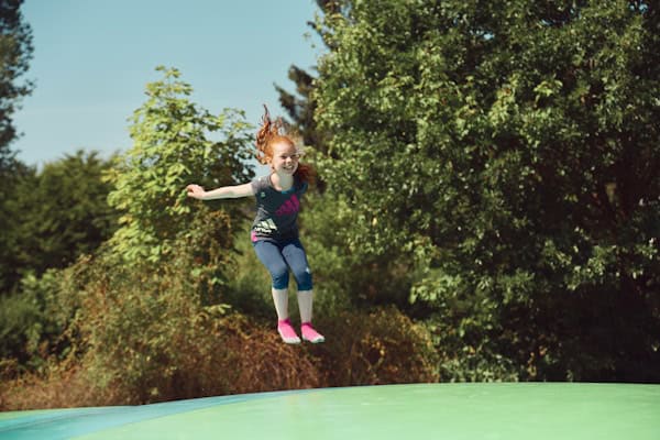 Kind springt fröhlich auf einem Trampolin