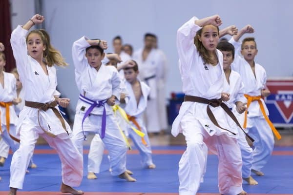 Gruppe Kinder mit Lehrer machen Kampfsport in Halle