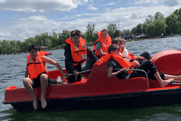 Kinder fahren im Abenteuercamp am Ammersee mit dem Tretboot