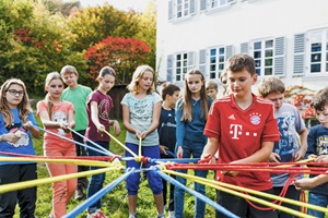 Kinder bei einer Teambuilding-Aufgabe im Englisch Natur & Klima Camp