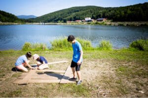 Kinder bauen ein Floß beim mystisches Abenteuercamp