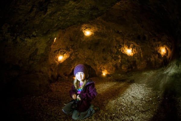Mädchen sitzt in einer Höhle