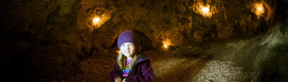 Ein Mädchen sitzt in einer Höhle
