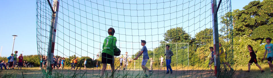 Kinder spielen Fußball auf einer Wiese