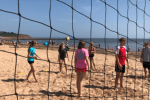 Jugendliche spielen Volleyball am Meer