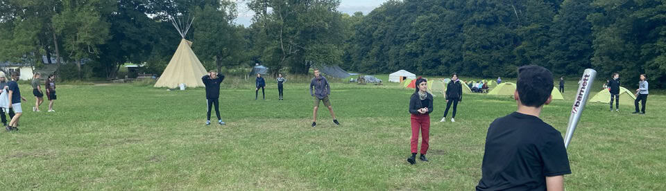 Kinder spielen Baseball auf der Wiese