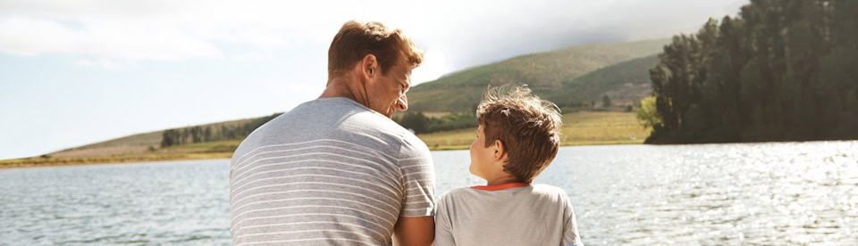 Vater und Sohn sitzen am See