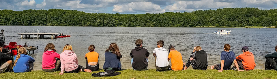 Jugendliche sitzen am See