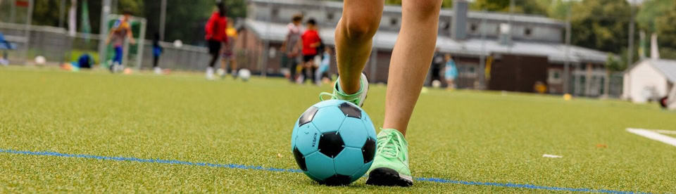 Ein Mädchen spielt Fußball im Sportcamp