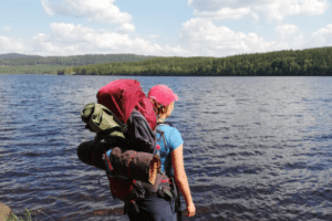 Mädchen mit Trekkingrucksack im Outdoorcamp Schweden