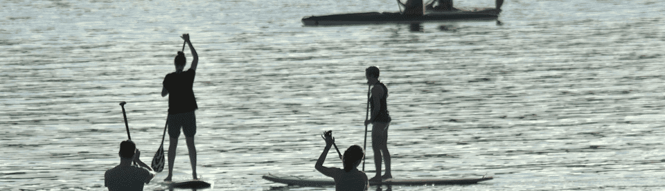 Jugendliche machen Stand-Up-Paddling auf einem See