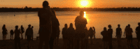 Menschen am See beim Sonnenuntergang