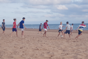 Jugendliche spielen Fußball am Strand