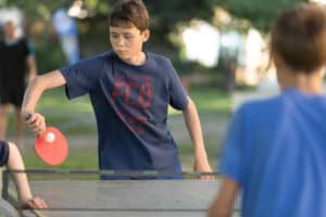 Kinder die Tischtennis gegeneinander spielen