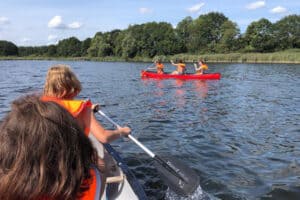 Kinder fahren Kanu auf einem See