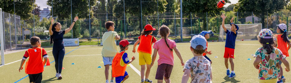 Kinder spielen Football im Outdoor Camp