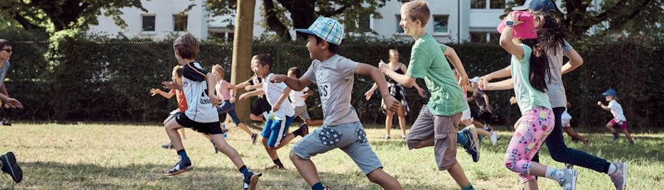 Kinder spielen und toben auf einer Wiese