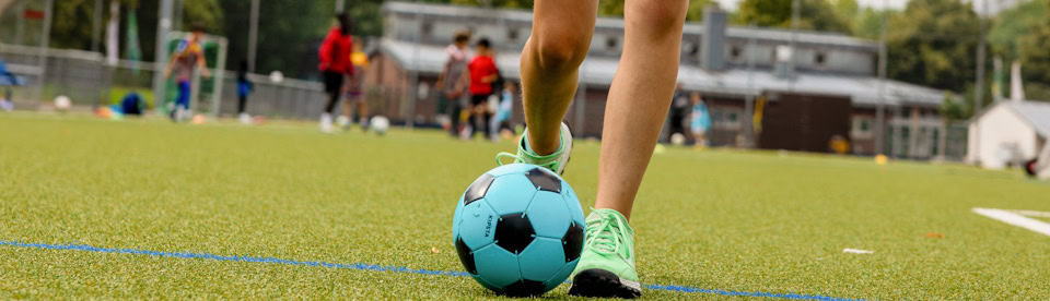 Mädchen dribbelt mit Ball am Fuß