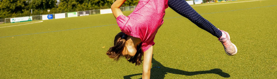 Mädchen macht einarmigen Handstand