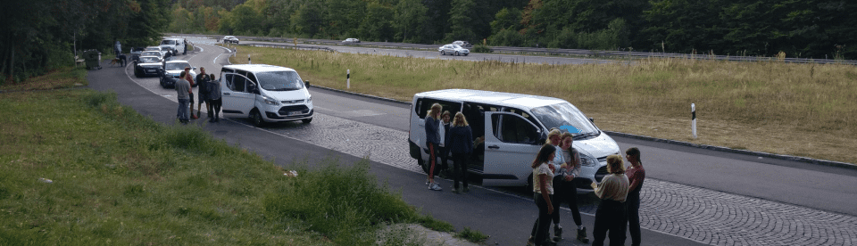 Jugendliche vor einem Minivan