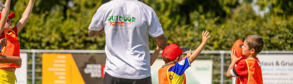 Junge wirft Football im Outdoor Kids Fußball Camp