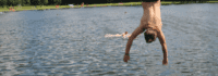 Ein Junge macht einen Rückwärtssalto in einen See