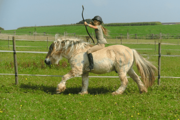 Mädchen mit Pfeil und Bogen auf Pferd