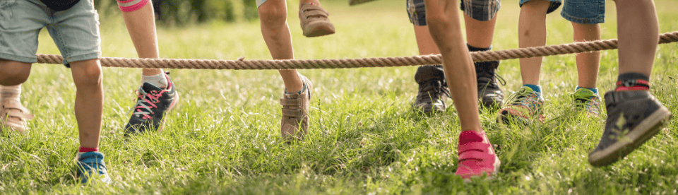 Kinder springen zusammen Seilchen