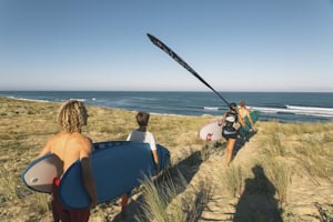 Jugendliche machen sich auf den Weg zum Surfen