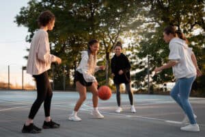 Kinder spielen Basketball afu einem Freiluftplatz 