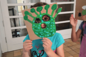 Kind mit gebastelter Maske