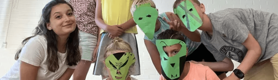 Kinder mit grünen gebastelten Masken