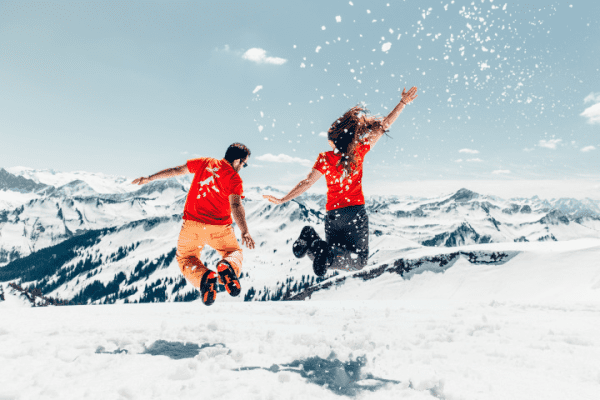 Junge und Mädchen springen im Schnee